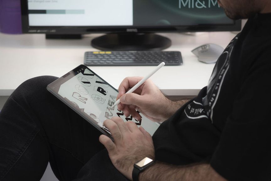 man tekent digitale logo's met een pencil op een tablet